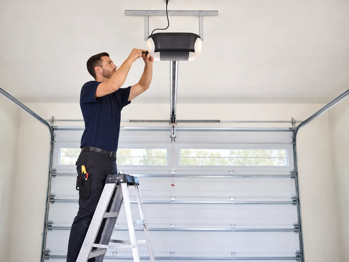 Technician servicing a ceiling-mounted garage door opener